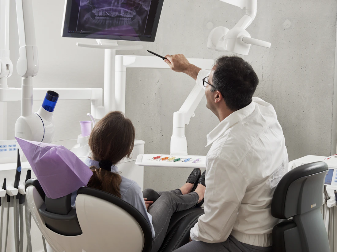 A dentist reviewing a dental X-ray with a patient in the practice